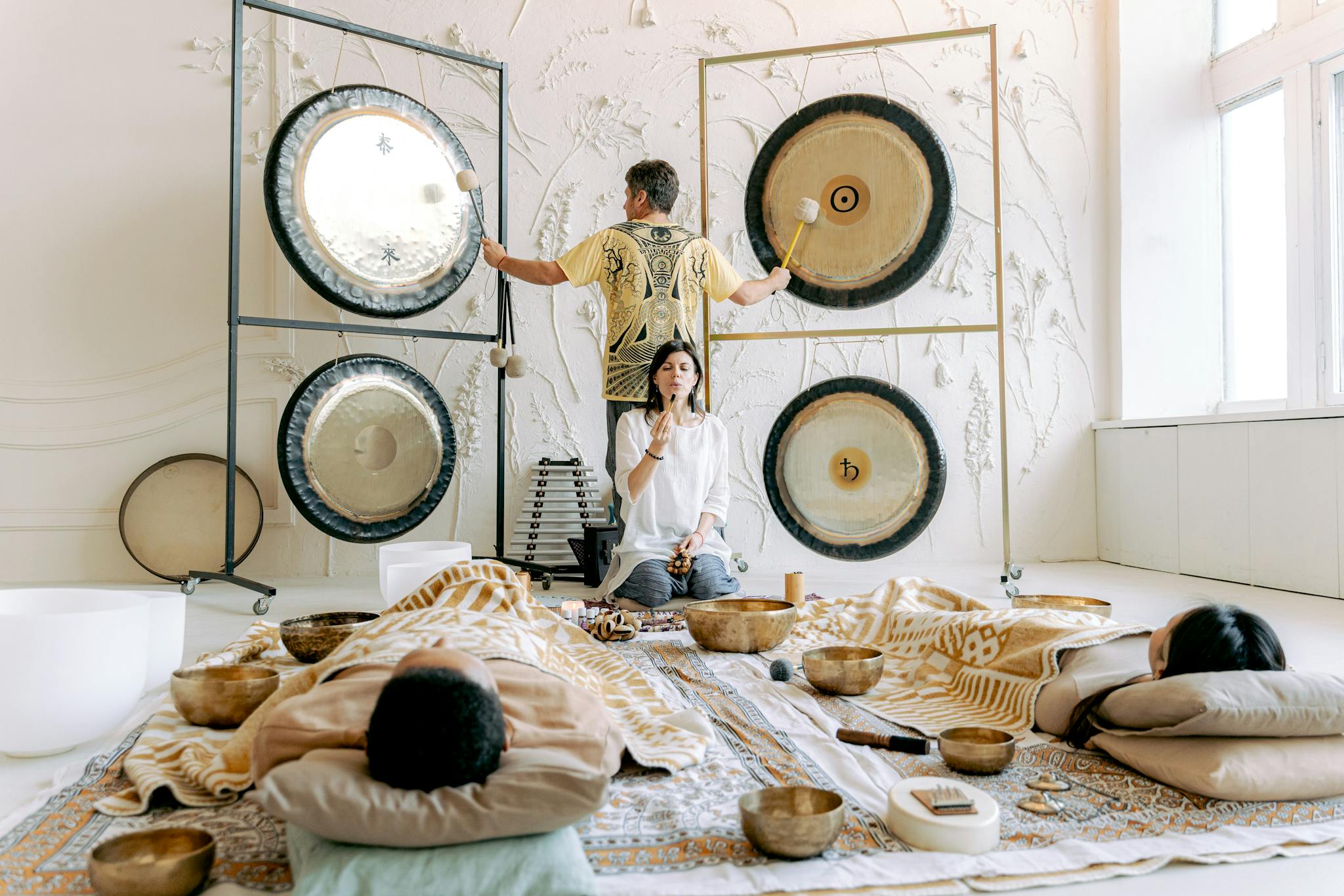Experience tranquility in a calming sound bath with singing bowls and gongs promoting relaxation and well-being.
